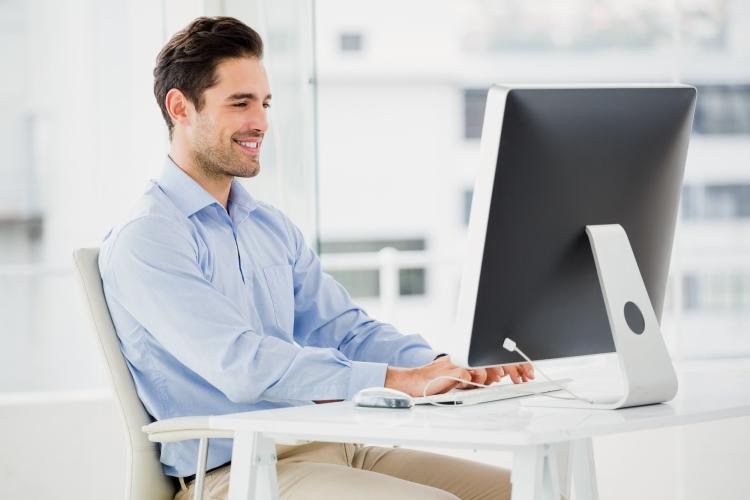 Businessman sitting at desk, working on computer