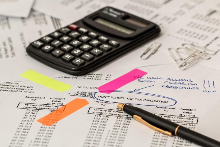 Calculator and pen laying on top of financial documents