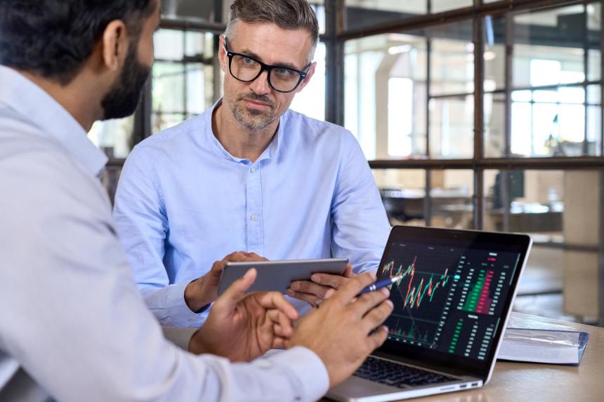 Businessman listening to coworker at office table