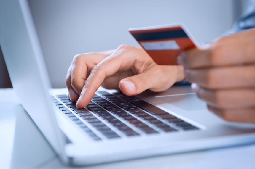 Man typing credit card information into laptop